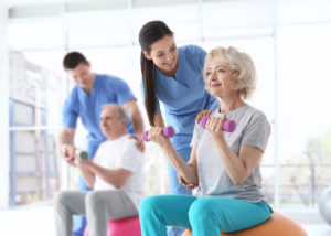 Physiotherapists working with elderly patients in modern clinic