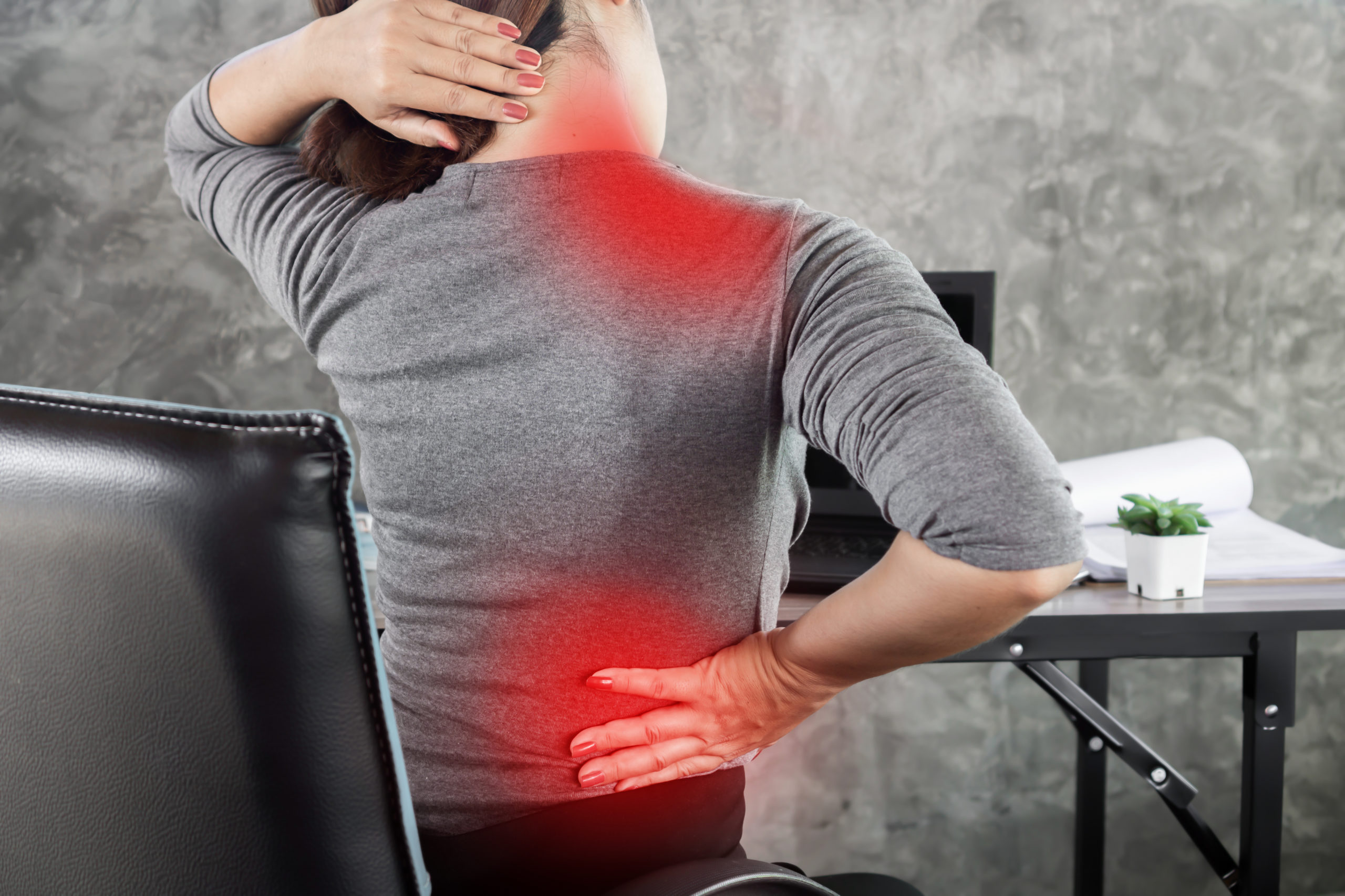  suffering from office syndrome having lower back pain, neck and shoulder pain sitting on chair