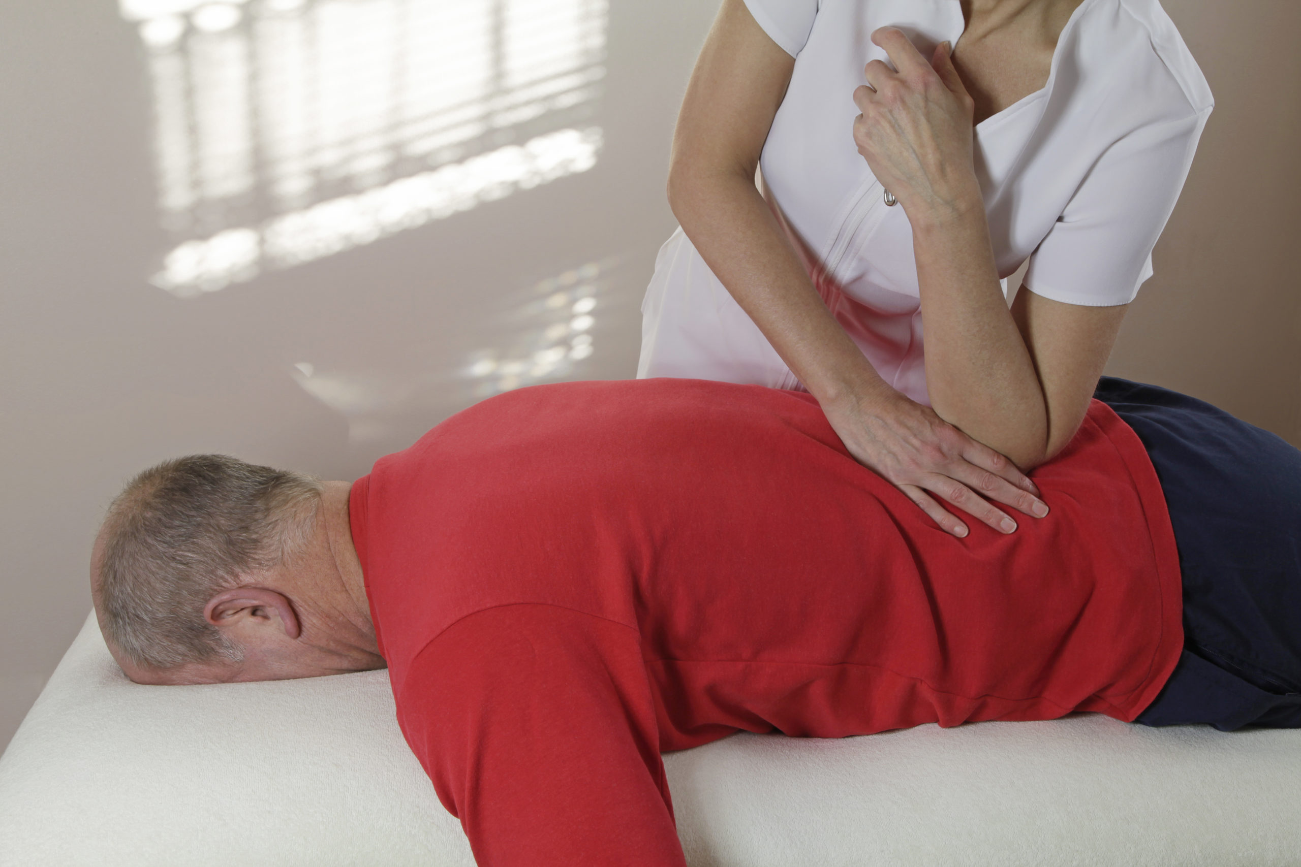 Massage therapist pressing elbow into back